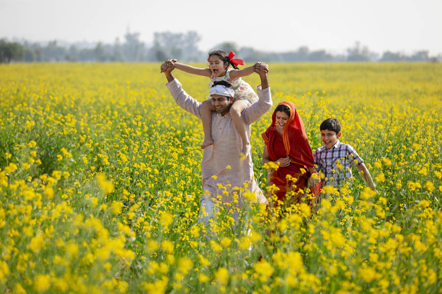 A farming family walking through a mustard field