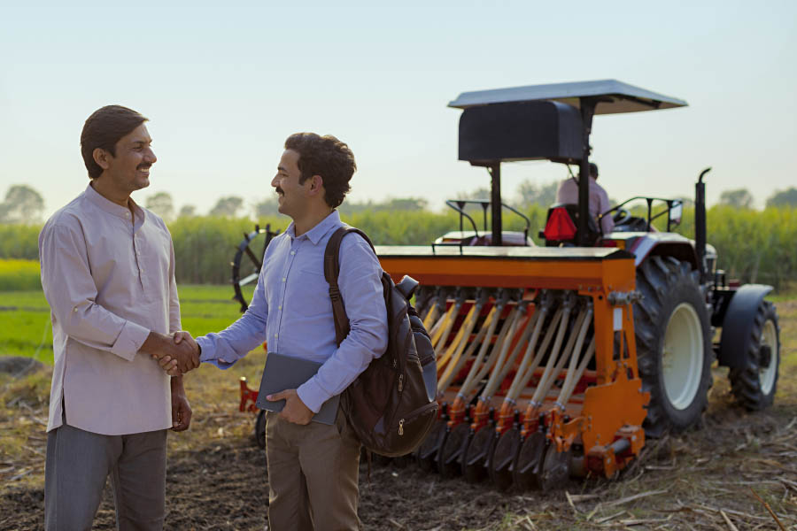 Two farmers shaking hands on a land agreement